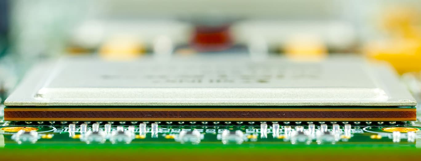 Close-up of a white electronic package mounted on a circuit board